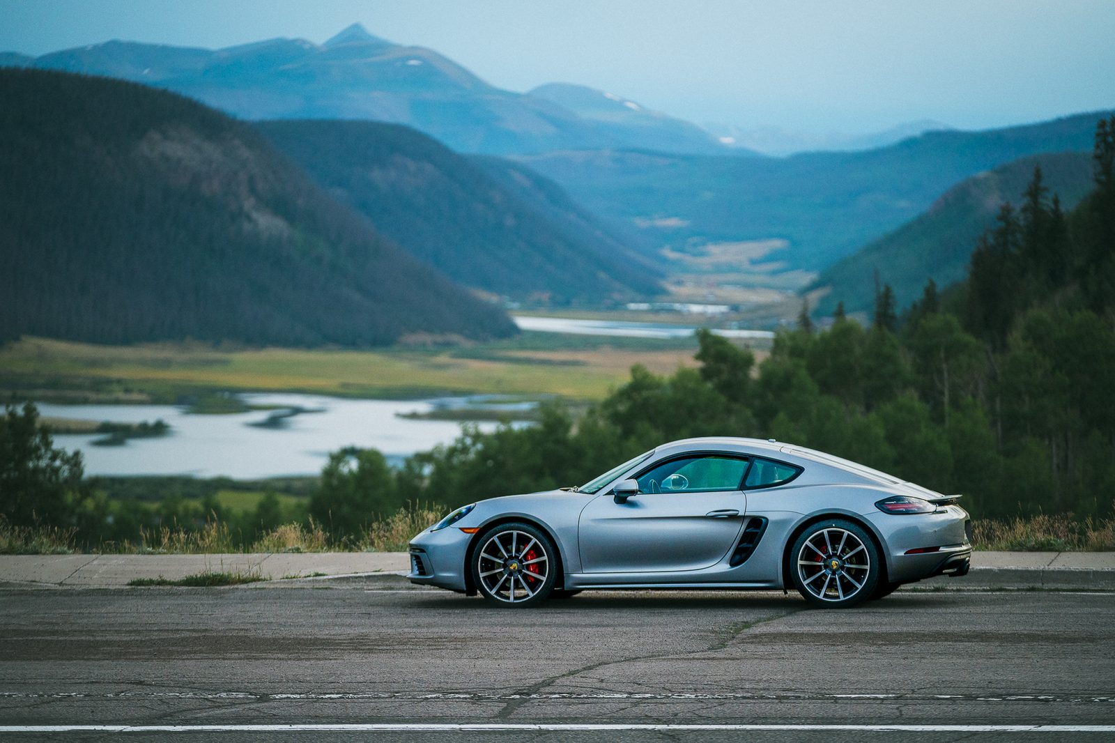 A Porsche 718 on a mountain road above the treeline